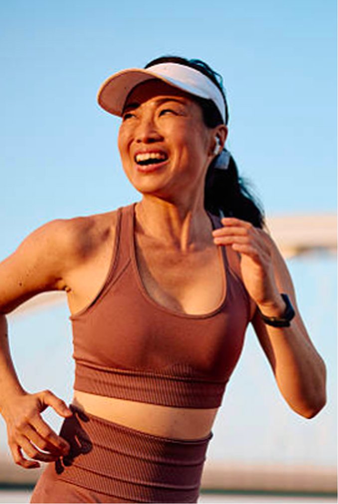 A woman running outdoors in athletic wear after medical weight loss treatment