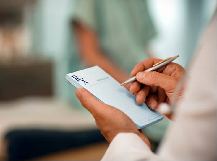 A clinician signs a prescription during a medical weight loss consultation